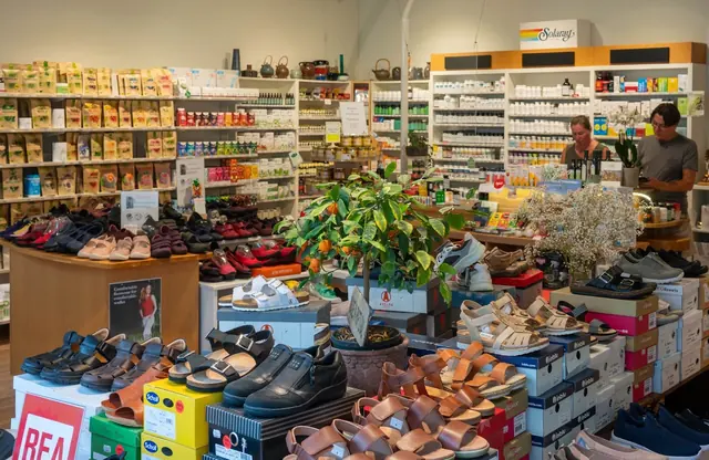 Överblick av Hälsokraft Orminge med skor i förgrunden och produkthyllor och disk bakom